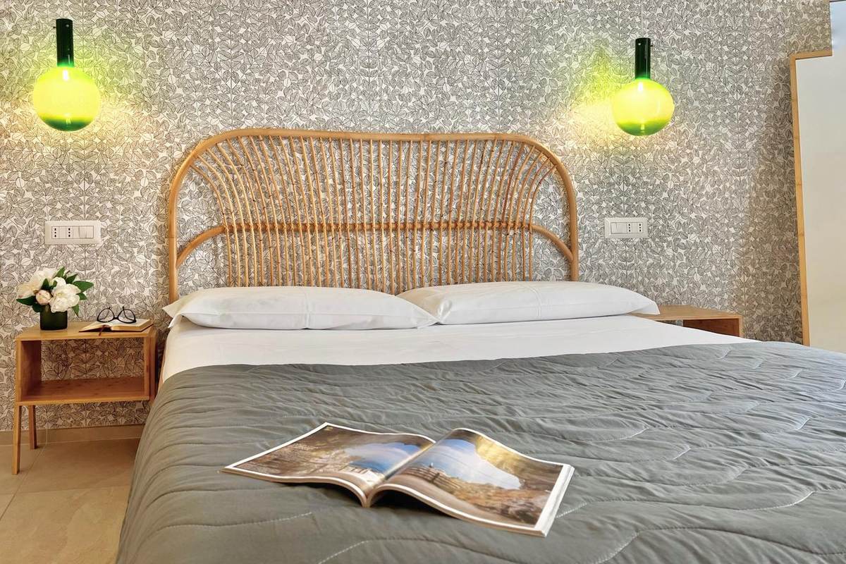 Letto matrimoniale con lampade in vetro verde