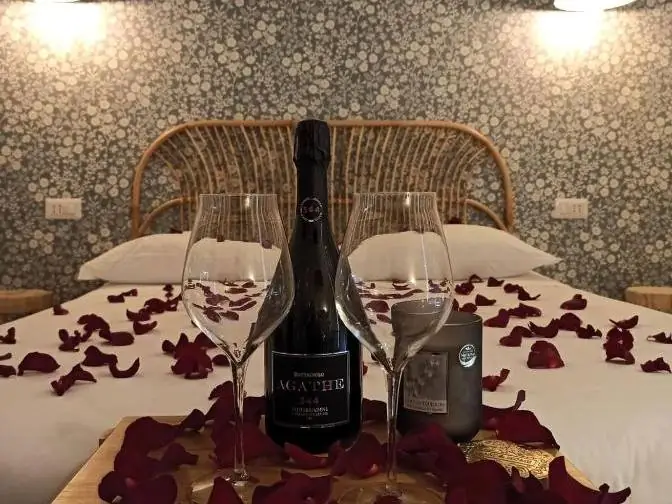 Camera decorata con petali di rosa, bottiglia e calici
