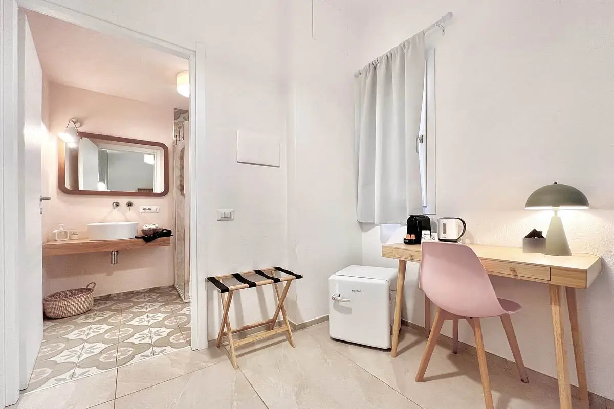 Angolo scrivania, minifrigo e bagno