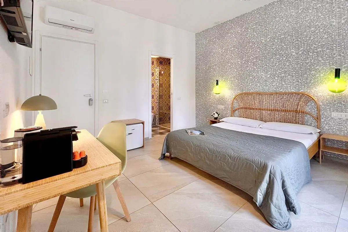 La camera vista dalla scrivania, con minifrigo e ingresso al bagno